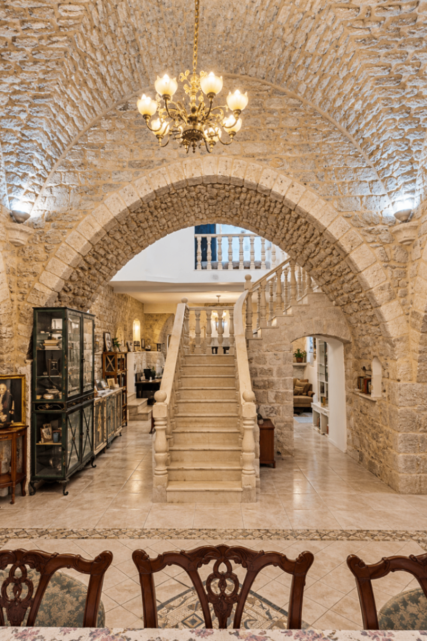 מבט דרך קשת אבן אל גרם מדרגות אבן רחב עם מעקות מגולפים